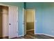 Bright blue bedroom featuring a closet, and door to an adjacent room, with wood look flooring at 369 James Cir, Lake Alfred, FL 33850