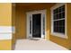 Inviting front porch of home with tile flooring, white columns, and a bright yellow exterior at 369 James Cir, Lake Alfred, FL 33850