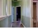 Hallway featuring light-colored walls, wood-look floors, and access to a bathroom and other rooms at 369 James Cir, Lake Alfred, FL 33850