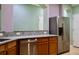 Granite counters, stainless fridge and dishwasher, and wooden cabinets create a functional kitchen space at 369 James Cir, Lake Alfred, FL 33850