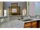 Kitchen sink and granite counters open to the living room with modern stone fireplace at 369 James Cir, Lake Alfred, FL 33850