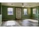 Bright living room features a decorative fireplace, wood-look flooring, and natural light from three windows at 369 James Cir, Lake Alfred, FL 33850