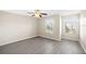 Bright bedroom features light-colored walls, ceiling fan, and new gray wood-look flooring at 380 Carina Cir, Sanford, FL 32773