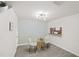 Cozy dining area with a modern light fixture, decorative wallpaper, and passthrough to the kitchen at 380 Carina Cir, Sanford, FL 32773