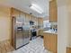 This kitchen features stainless steel appliances, light wood cabinets, and a window overlooking the yard at 4025 Luan Dr, Orlando, FL 32808