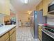 Bright kitchen with stainless steel appliances, light wood cabinets, and tile flooring throughout at 4025 Luan Dr, Orlando, FL 32808