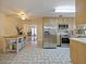 Open concept kitchen featuring stainless steel appliances, light wood cabinets, and a tile floor at 4025 Luan Dr, Orlando, FL 32808