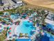 Aerial view of community pool with water slides, colorful umbrellas, and lush landscaping at 4098 Lana Ave, Davenport, FL 33897