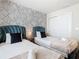 Bright bedroom featuring two beds with dark blue headboards and decorative leaf-print wallpaper at 4098 Lana Ave, Davenport, FL 33897