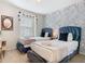 Bright bedroom featuring two beds with dark blue headboards and decorative leaf-print wallpaper at 4098 Lana Ave, Davenport, FL 33897