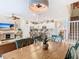 Open concept dining area with rustic table, stylish chairs, leading into a modern kitchen and living space at 4098 Lana Ave, Davenport, FL 33897