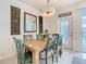 Bright dining room with a rustic wood table, stylish chairs, and a modern chandelier fixture at 4098 Lana Ave, Davenport, FL 33897