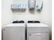 Bright laundry room featuring modern, white washer and dryer with convenient shelving at 4098 Lana Ave, Davenport, FL 33897