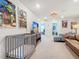 Bright living room area featuring a crib, sofa, love seat, and television at 4098 Lana Ave, Davenport, FL 33897