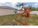 Backyard featuring a playset, palm trees, and a partial view of the home at 427 Highland Meadows St, Davenport, FL 33837