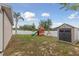 Spacious backyard features a playset, storage shed, and a white fence, ideal for outdoor activities and relaxation at 427 Highland Meadows St, Davenport, FL 33837