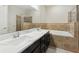 Bathroom featuring double sinks, granite countertops, dark cabinets, and tiled shower/tub enclosure at 427 Highland Meadows St, Davenport, FL 33837