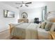 Spacious bedroom with a large bed, neutral walls, ceiling fan, and round mirror adding a touch of elegance at 427 Highland Meadows St, Davenport, FL 33837