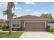 Charming single-Gathering home featuring a two-car garage, well-manicured lawn, and tropical landscaping at 427 Highland Meadows St, Davenport, FL 33837
