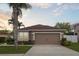 Charming single-Gathering home featuring a two-car garage, well-manicured lawn, and tropical landscaping at 427 Highland Meadows St, Davenport, FL 33837