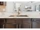 A close-up shot of a stainless steel sink and light marble countertops in a modern kitchen with dark wood cabinets at 427 Highland Meadows St, Davenport, FL 33837