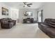 Open living room features hardwood floors, a ceiling fan, a fireplace, and ample seating with leather couches at 427 Highland Meadows St, Davenport, FL 33837