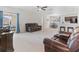 Spacious living room with hardwood floors, fan, open to kitchen with breakfast bar, and ample seating at 427 Highland Meadows St, Davenport, FL 33837