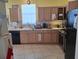 A kitchen with wood cabinets, black appliances, and tile flooring at 450 Morning Blossom Ln, Oviedo, FL 32765