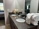 Bathroom featuring a double vanity with granite counters, decor, and fluffy white towels near a mirrored wall at 457 Bridgeford Crossing Blvd, Davenport, FL 33837