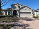 Charming single-Gathering home featuring a brick driveway and a neutral-toned stucco exterior at 457 Bridgeford Crossing Blvd, Davenport, FL 33837
