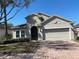 Stucco home with attached garage and paver driveway and some landscaping at 457 Bridgeford Crossing Blvd, Davenport, FL 33837