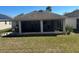 Screened-in patio with outdoor seating area, adjacent to a well-maintained yard and grill at 457 Bridgeford Crossing Blvd, Davenport, FL 33837