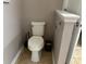 A powder room that features a white toilet, tile floors, and a neutral color palette at 457 Bridgeford Crossing Blvd, Davenport, FL 33837