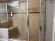 Shower showcasing elegant tiled walls, a glass door, and a convenient built-in bench at 457 Bridgeford Crossing Blvd, Davenport, FL 33837