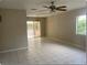 Bright living room with tile floors, ceiling fan, and sliding glass doors to the screened in patio at 4736 Southold St, Orlando, FL 32808