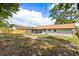 Exterior view of the home with a large backyard, screened-in patio, and fenced yard at 4800 Beacon St, Orlando, FL 32808