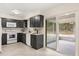 Modern kitchen featuring sleek cabinetry, white appliances, and a sliding door providing access to an outdoor patio at 4800 Beacon St, Orlando, FL 32808