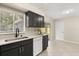 Bright kitchen featuring black cabinets, a white countertop, a dishwasher and tile floors at 4800 Beacon St, Orlando, FL 32808