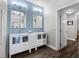 Modern bathroom with dual sinks, white cabinetry and mirrors, accentuated by blue wall at 501 Mirasol Cir # 519, Celebration, FL 34747