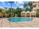 Community pool with relaxing lounge chairs and tables with mature landscaping and a clear blue sky at 501 Mirasol Cir # 519, Celebration, FL 34747