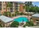 Beautiful pool area, cabana and mature landscaping surrounded by resort-style condominium building at 501 Mirasol Cir # 519, Celebration, FL 34747