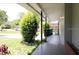 A covered porch providing shade and shelter, with greenery and a glimpse of the neighborhood beyond at 532 Madison Ave, Orlando, FL 32805