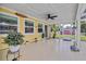 Relaxing enclosed patio features a ceiling fan and a great view of the yard and garden at 5800 Spruce Creek Woods Dr, Port Orange, FL 32127