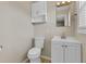 Bright bathroom featuring a vanity with storage, a toilet, and a light fixture at 5800 Spruce Creek Woods Dr, Port Orange, FL 32127