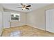A neutral bedroom with tile flooring, a ceiling fan, and a window with natural light at 5800 Spruce Creek Woods Dr, Port Orange, FL 32127