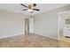 Bedroom featuring tile floors, a ceiling fan, neutral paint, and access to the bathroom at 5800 Spruce Creek Woods Dr, Port Orange, FL 32127