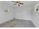 A compact, simple bedroom featuring a neutral palette, a window, and a ceiling fan at 5800 Spruce Creek Woods Dr, Port Orange, FL 32127