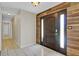 Bright foyer with a rustic wood wall accent, light tile flooring, and neutral wall paint at 5800 Spruce Creek Woods Dr, Port Orange, FL 32127
