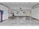 Spacious garage with white walls, concrete floor, storage cabinets, and two windows, offering ample storage and natural light at 5800 Spruce Creek Woods Dr, Port Orange, FL 32127