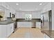Modern kitchen features white cabinets, granite counters, stainless steel appliances, and tile backsplash at 5800 Spruce Creek Woods Dr, Port Orange, FL 32127